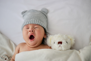Baby yawning with teddy bear