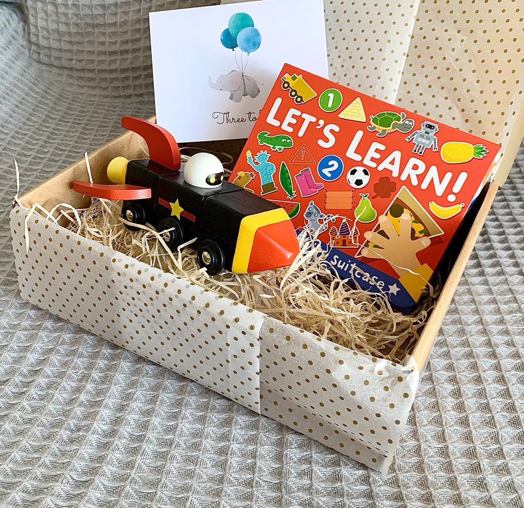 Third birthday gift box with wooden space rocket, let's learn activity suitcase and three today card